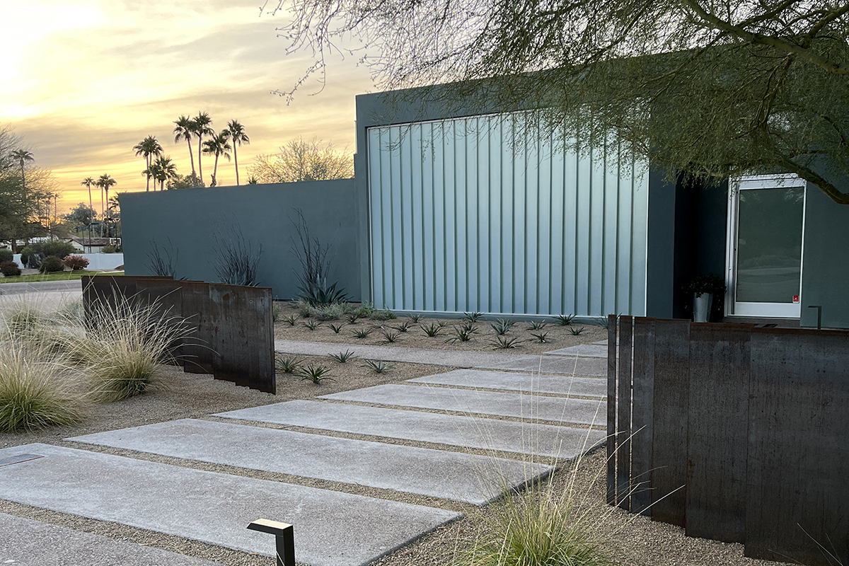 Custom contemporary desert front yard landscape design by On Site Landscape. We implemented a gridded planting design featuring grasses, agaves, yuccas, and desert marigolds on an angle, echoing the sleek lines of this Paradise Valley home. The front yard features aesthetic steel paneling, aligned with the Fibonacci sequence for an added touch of contemporary sophistication. Saw-cut walkways enhance the modern look.